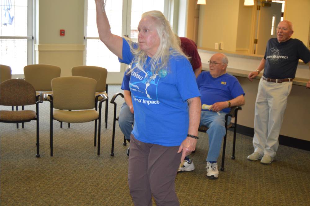 A senior playing a game of Wii Bowling.